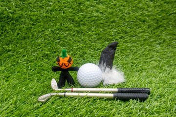 Happy Halloween to golfer with golf ball and ghost on green grass