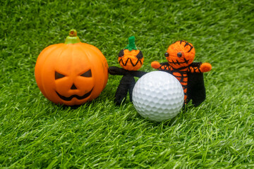 Happy Halloween to golfer with golf ball and ghost on green grass