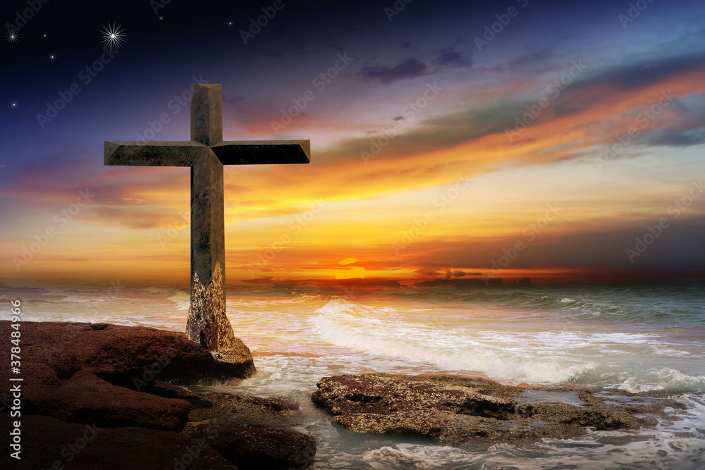 Wall mural Crucifix crucifixion Jesus Christ on the rocks by the sea at sunset.