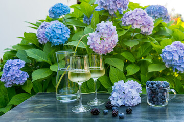 Glasses with white wine on a table in a floral
garden on a summer evening as a rest after work