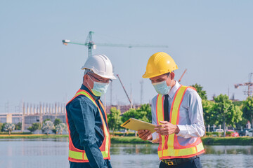 Businessman in medical mask talking on site construction by tablet technology