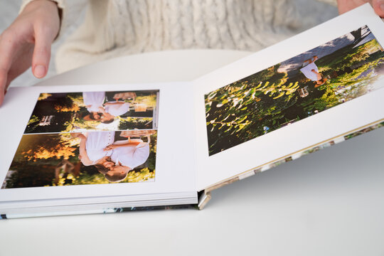 close up. a woman flips through a photo book from a family pregnancy photo shoot. beautiful and convenient storage of photos. memory of an important period.