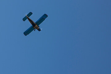 
small plane flying in the blue sky