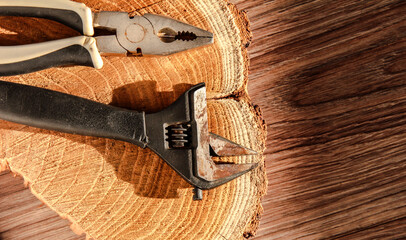 Obraz na płótnie Canvas Old wrench and pliers on a wooden background.
