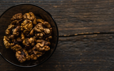Walnut in a small plate on a vintage wooden table. Walnuts is a healthy vegetarian protein nutritious food. Natural nuts snacks.