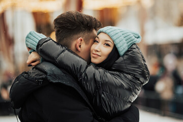 Close up of couple in love embracing on the city street. Beautiful woman  relaxing in her man's arms. Close-up of a loving hugging young couple. Sincere feelings.