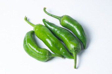 Green hot peppers on a white background. Several green hot peppers are lying next to each other. Healthy vegetables