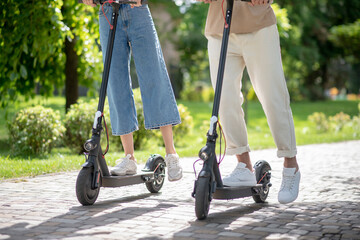 Obraz premium Close up picture of two people riding scooters