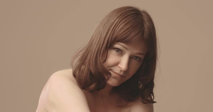 Smiling middle aged Caucasian woman . Brown- haired . Hug. Nude. High quality 4k footage