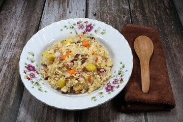 Traditional fried and stirred cooked rice with fresh ginkgo (Biloba), chopped carrot, sliced onion, egg and cutting pork meat on the plate. Famous special street food menu in Asia. 
