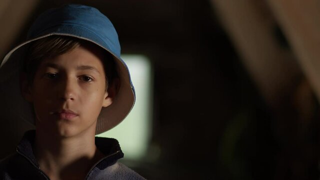 portrait of a boy in a blue hat looking at the camera, indoors