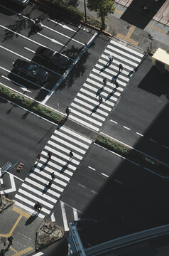 Aerial View Pedestrians Crossing City Street At Crosswalk, Tokyo, Japan
