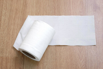 Toilet paper on the wooden table background.