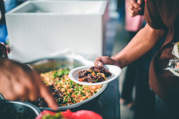 donate food to the homeless : The hands of the poor handed a plate to receive food from volunteers...