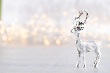 Christmas reindeer on bokeh silver background. Christmas or New Year minimal concept.