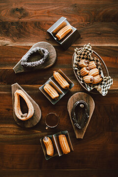 Overhead view of assorted churros on wooden table
