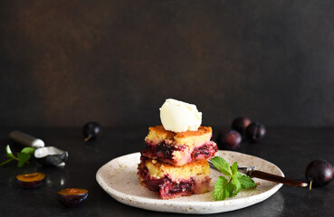 Cupcake with plums and vanilla ice cream on a dark background. Fruit pie with mint.