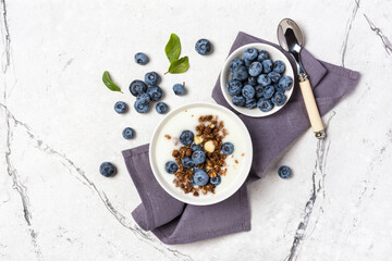 Healthy breakfast of white yogurt with chocolate granola and blueberry berries