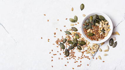 White bowl with different seeds as snack, ingredient for oil, mix for healthy salad