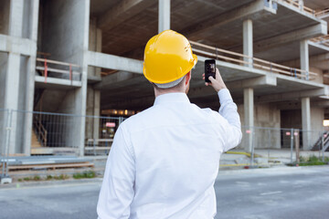 Builder Taking Photos by Phone of Cunstruction Works. Man in Hardhat. House Building