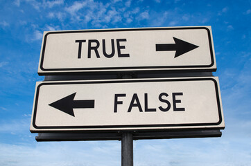 True vs false. White two street signs with arrow on metal pole with word. Directional road....