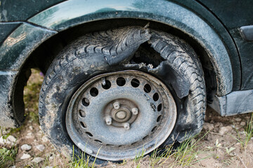 Fototapeta na wymiar Broken car on the road with damaged tire and disk 