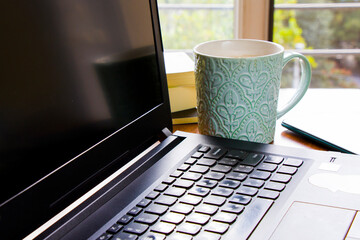 Workspace at home, notebook, mobile device, coffee and plants on the table