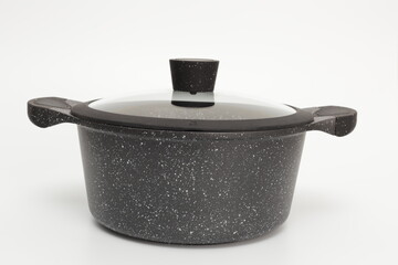 Black casserole with a lid on a white background.
