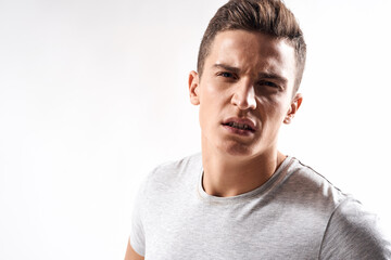 sporty man in white t-shirt on a light background gesturing with his hands cropped view Copy Space