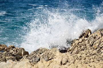 waves breaking against the rocks at the beach
