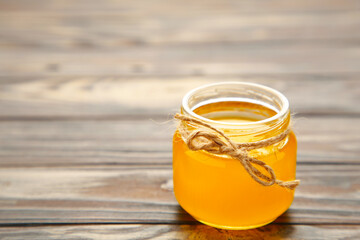Jar of honey on grey wooden table