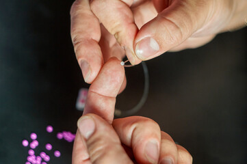 the girl makes beadwork, beading as a hobby. Jewelry made with your own hands