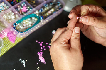 the girl makes beadwork, beading as a hobby. Jewelry made with your own hands
