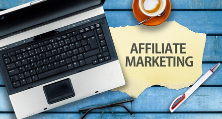 Affiliate marketing.  Paper width words Affiliate marketing and laptop on wooden table