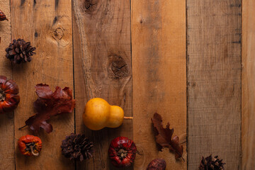 Wooden background with small pumpkins and dry leaves, autumn composition