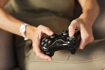 Close-up of woman pushing buttons on joystick she playing in computer game