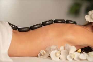 Woman getting a hot stone massage at spa salon