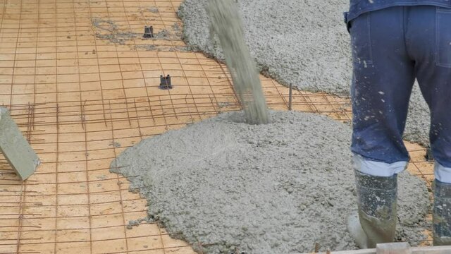 The process of pouring concrete on a prepared base made of sand and reinforced with a metal mesh