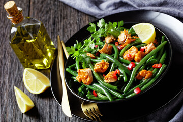 Curried salmon with green beans on a black plate