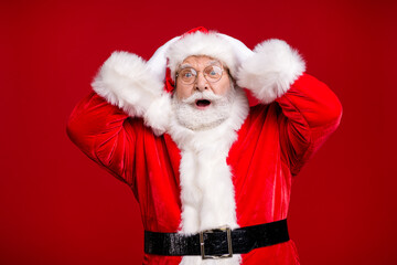 Photo of pensioner old man grey beard open mouth hands head shocked terrified late newyear party event wear santa costume belt coat spectacles headwear isolated red color background