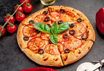 pizza margarita with basil on a stone background