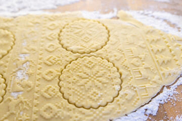 Making cookies for the New Year's table, festive food. Dough with Christmas pattern rolled out on the table