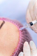 Injection in forehead. Selective focus. Cropped photo. Beauty clinic.