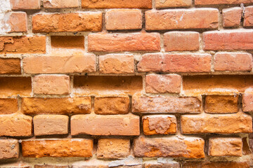 Fototapeta premium Brick wall with uneven masonry. Orange brick