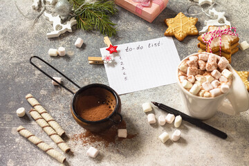 Fototapeta na wymiar Christmas background. A cup of hot cocoa with marshmallows and Christmas baking on a stone countertop.