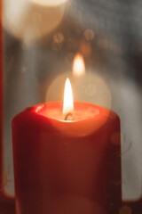 Red burning Christmas candle in female hands