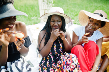 Group of african american girls celebrating birthday party and eat muffins outdoor with decor.