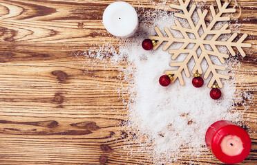 Wooden board with snow and red Christmas baubles