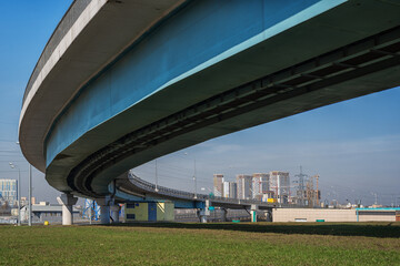 Urban landscape with a curved overpass and a residential complex under construction in the background