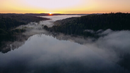 Sunrise on the lake with fog. Panorama view from a height of flight on a drone.
